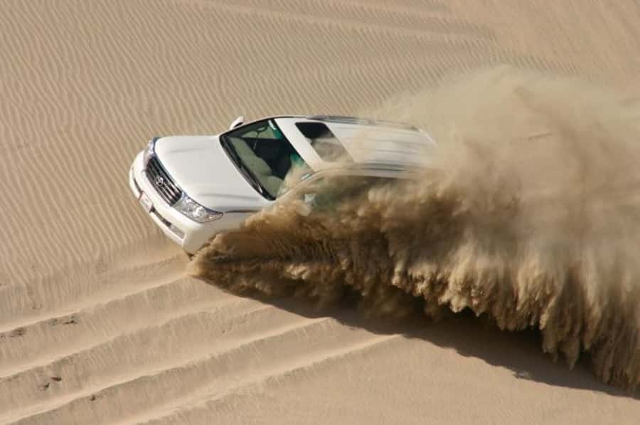 Dune Bashing, Sandboarding, Camel Ride & Optional ATV Ride - Sandboarding on the dune face